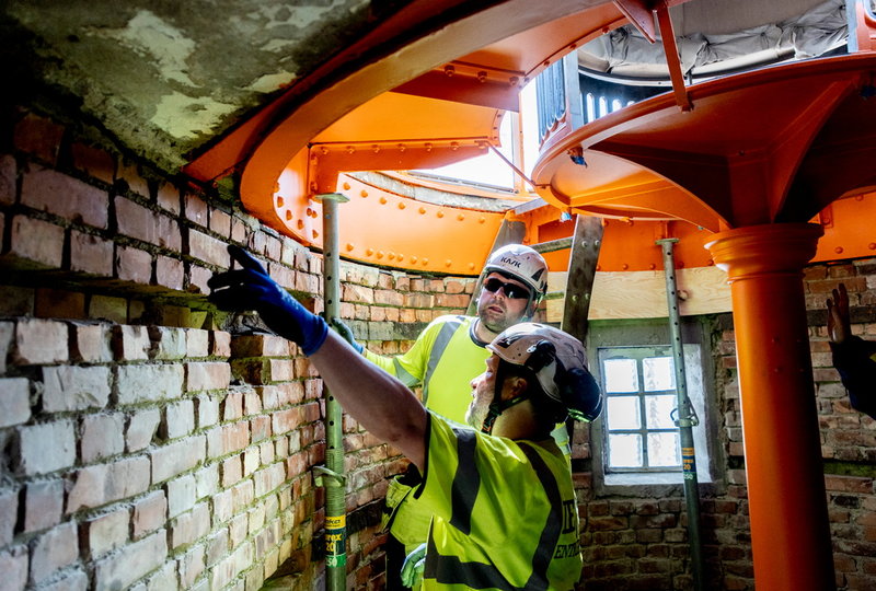 Przemyslav Karsas och Niklas Orava inspekterar renoveringen av Tistlarnas fyr. Under projektets gång hyr byggjobbarna in sig i ett av husen på ön.
