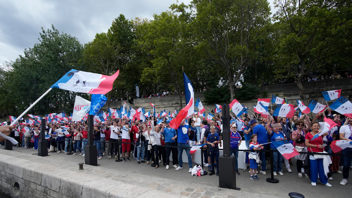 Franska supportrar längs floden Seine i samband med att den olympiska facklan visades upp i Paris förra sommaren. Arkivbild.