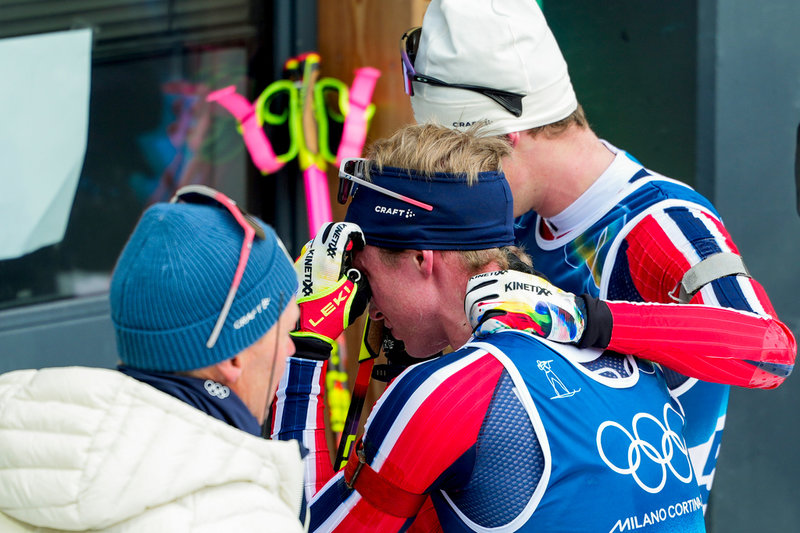 En tagen Johan-Olav Botn kramas om av ledare och lagkamrater efter sitt OS-guld på skidskyttets distanslopp över 20 kilometer.
