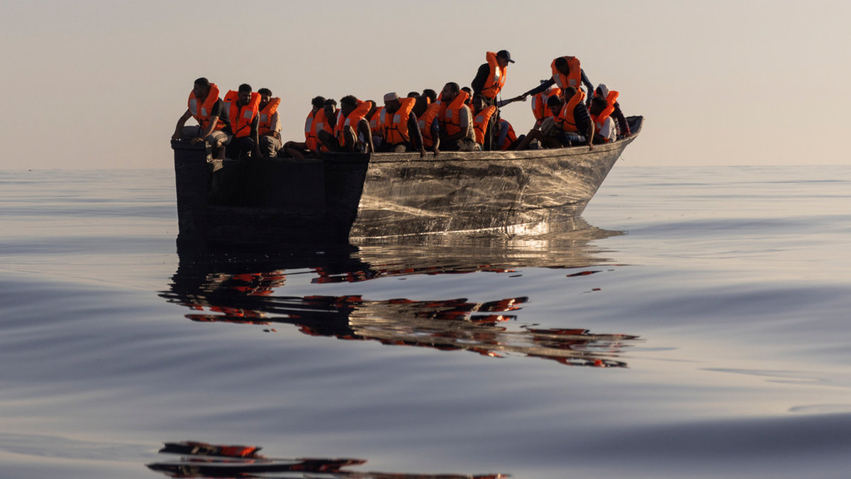 Migranter i en båt cirka 26 sjömil söder om den italienska ön Lampedusa i augusti i fjol. Arkivbild.