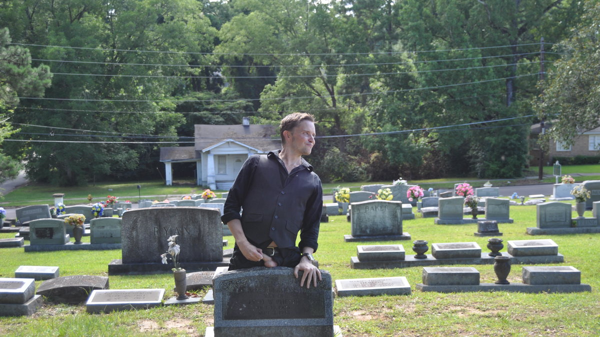 Här lägger Greaves sitt paket på gravstenen.