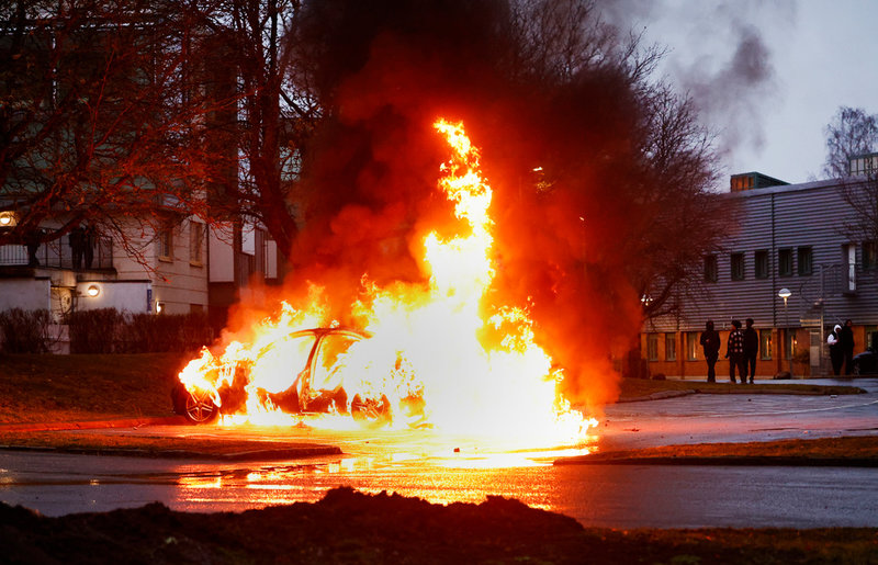 En bil som satts i brand under det första upploppet i Navestad, Norrköping, den 14 april.