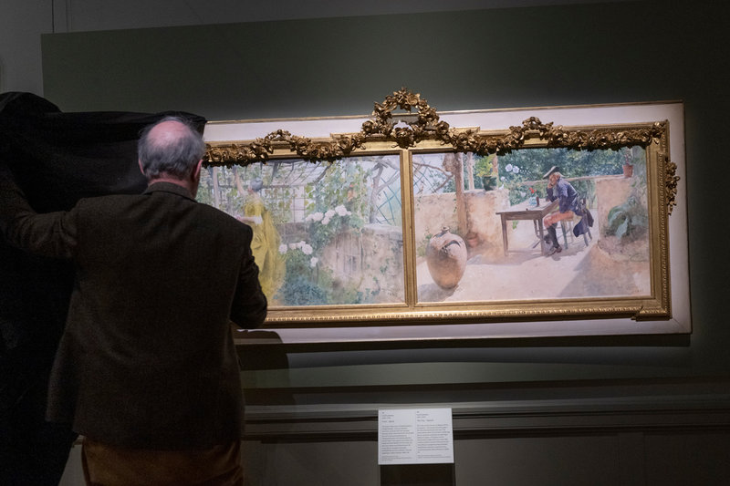 Kuratorn Magnus Olausson tar bort tyget från Carl Larssons 'Vinet' som visas på Nationalmuseum.