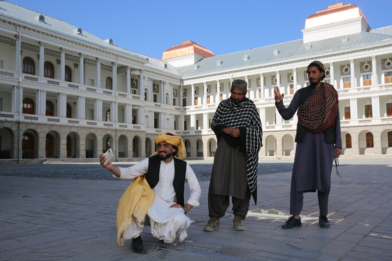 Afghaner tar selfies vid det nyrenoverade Darullamanpalatset sydväst om Kabul i april 2024.