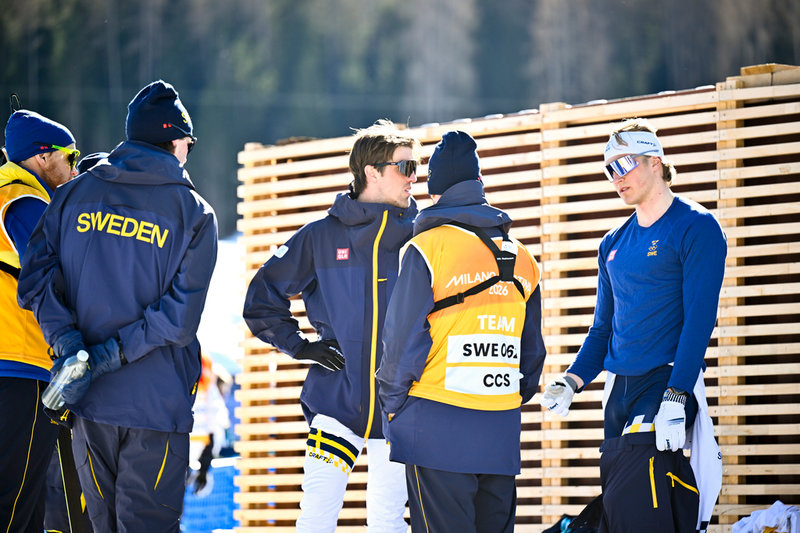 De svenska åkarna Calle Halfvarsson och Edvin Anger i samtal med ledare och vallare efter sistaplatsen i söndagens OS-stafett.