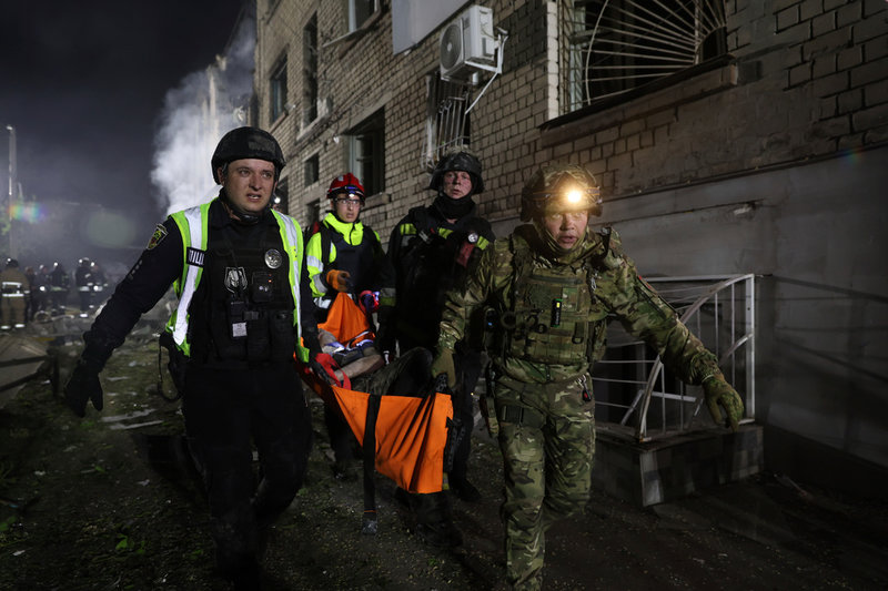 Zaporizjzja, den 1 maj: Poliser bär iväg en man som skadats i ett ryskt anfall mot ett bostadsområde mitt i natten.