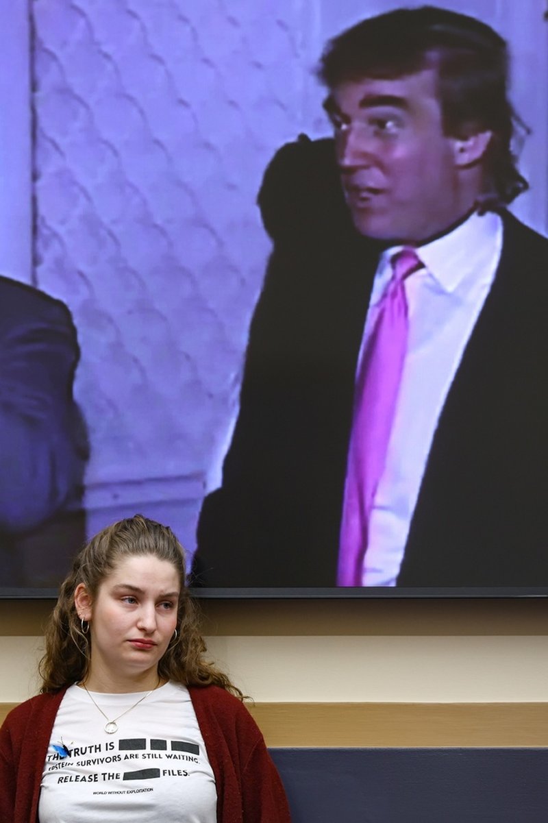 Utfrågningarna om Epstein-fallet sker i representanthusets mäktiga tillsynsutskott. Här lyssnar en åskådare under en tidigare förhandling, då en video med president Donald Trump (på skärmen bakom) tillsammans med Jeffrey Epstein spelades upp.