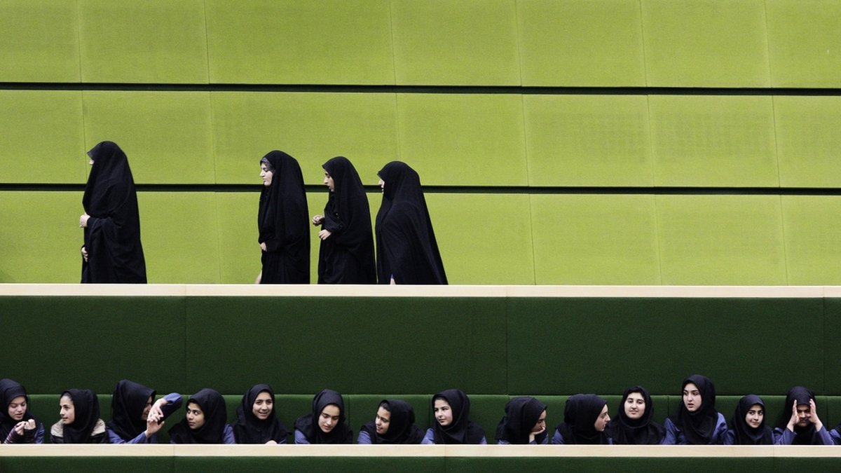En grupp kvinnliga skolelever lyssnar på en debatt i det iranska parlamentet. Arkivbild.