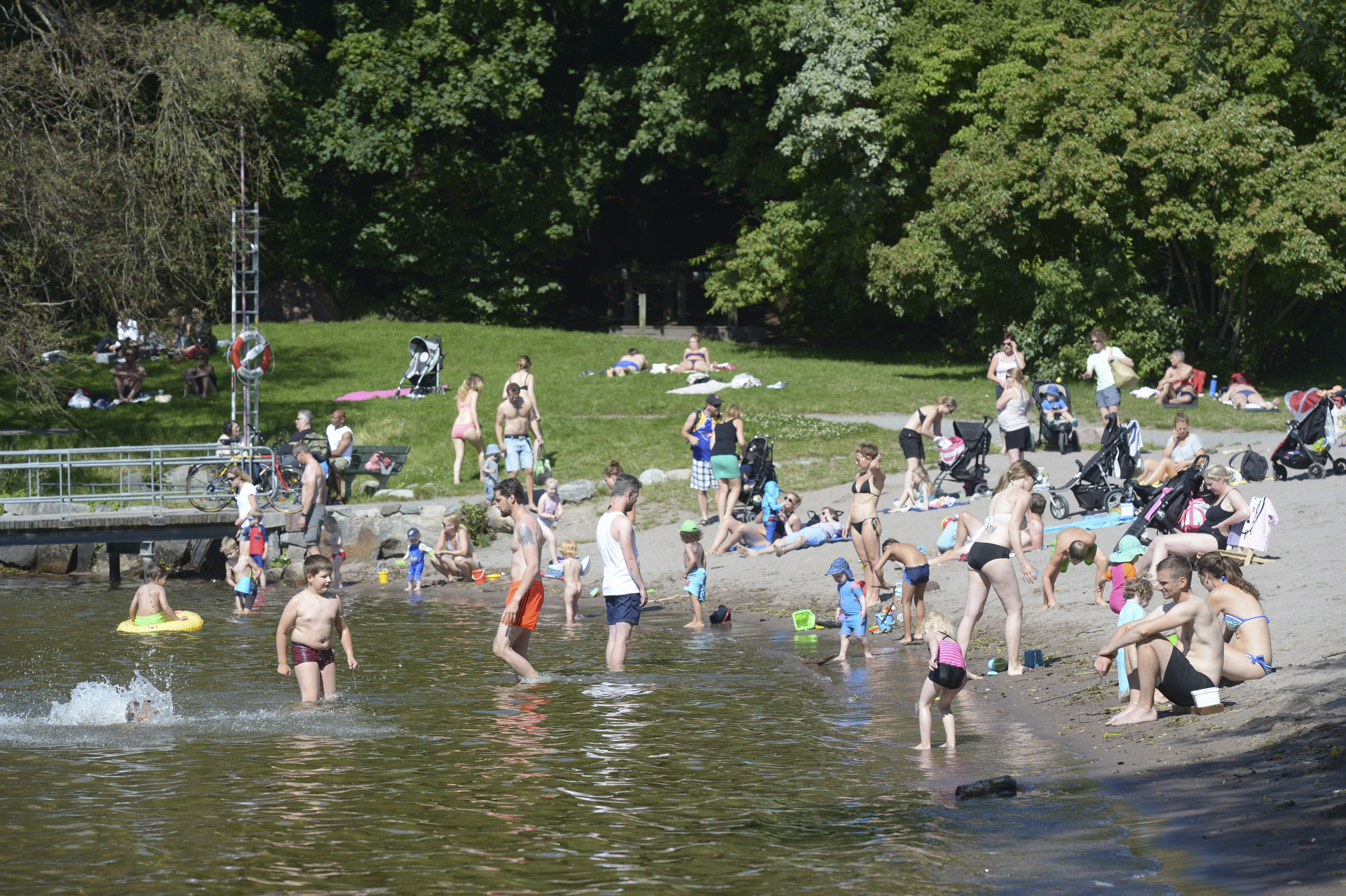 Människor badar vid en strand. Människor badar vid en strand.
