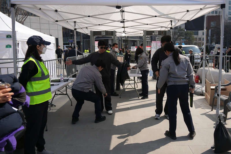 Konsertbesökare visiteras av polis.
