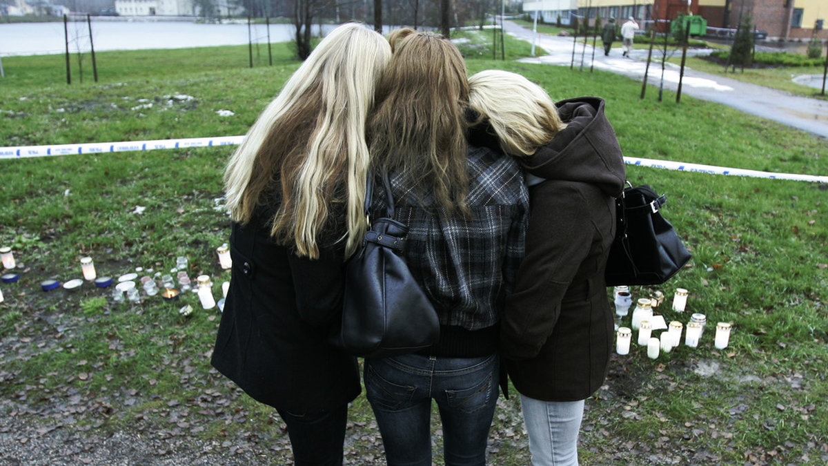 Tre elever tröstar varandra utanför skolan i Jokela, där nio personer dödades i en skolskjutning 2007. Arkivbild.