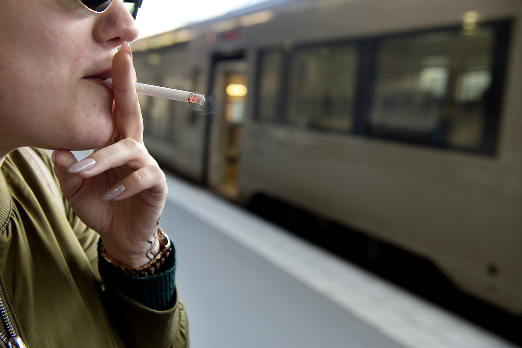 Kvinna som röker framför tåg Kvinna som röker framför tåg