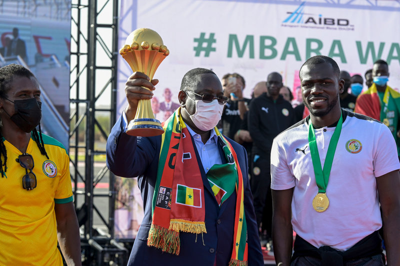 Presidenten Macky Sall håller upp pokalen.