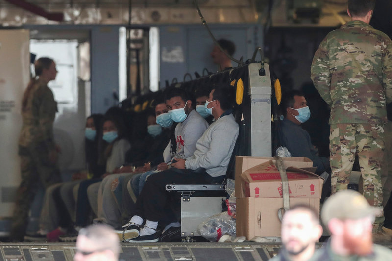Migranter väntar på att deporteras från USA med ett militärflygplan. Bild från Fort Bliss i Texas i fjol.
