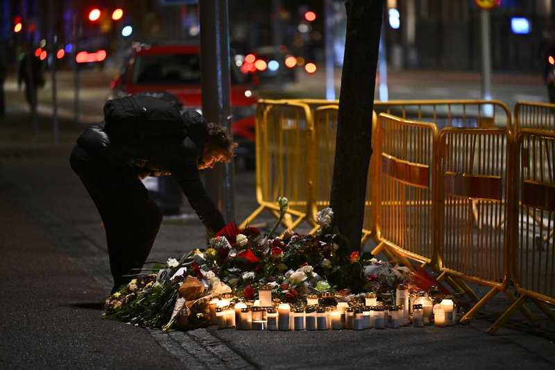 Sörjande lämnar blommor och ljus på olycksplatsen där tre personer omkom och flera skadades. Foto: Pontus Lundahl/TT