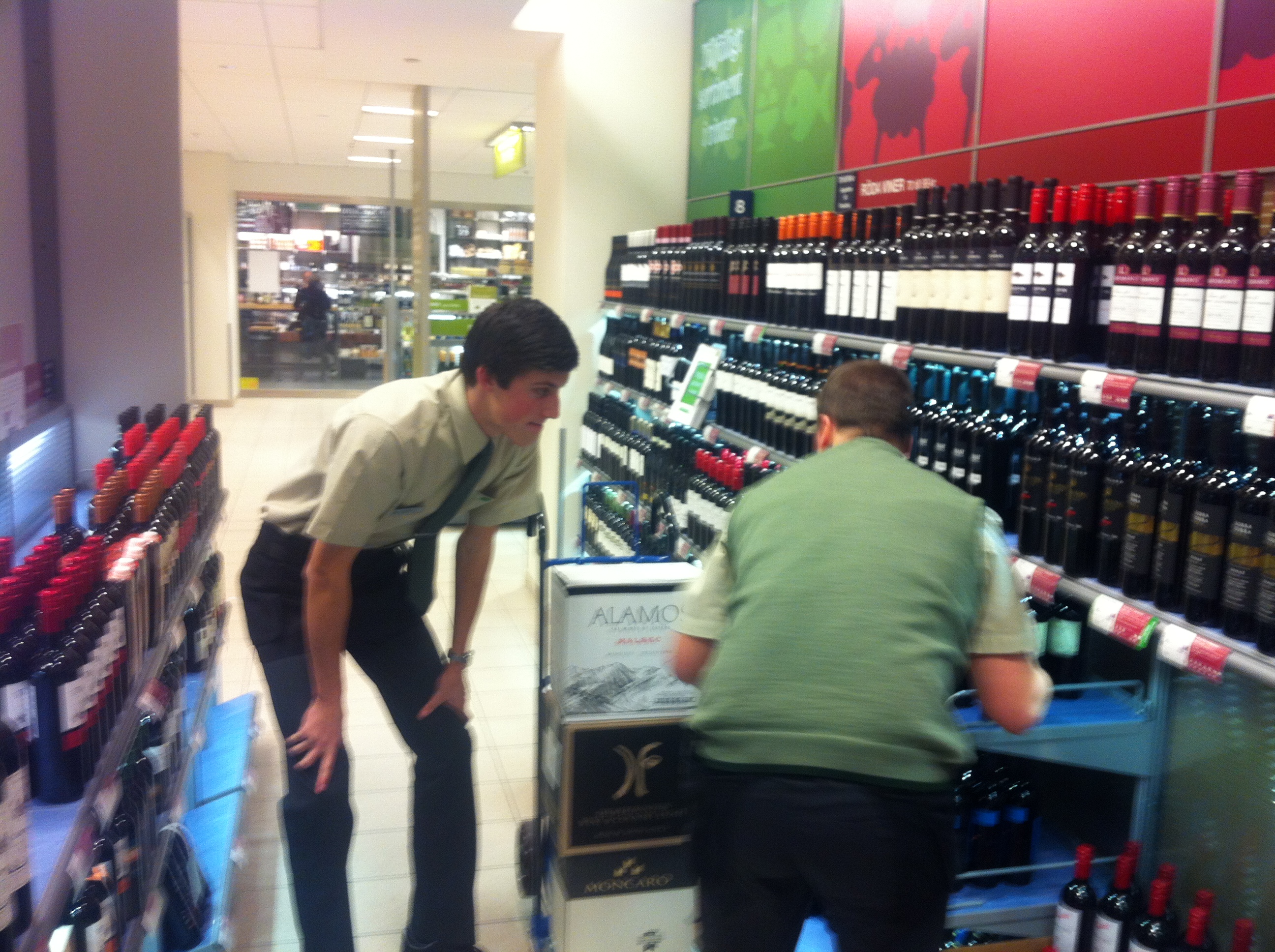 Här visar butikschefen hur Anton Abele ska ställa in flaskorna.