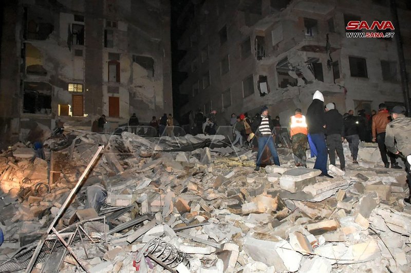 Bild från staden Hama i Syrien där räddningsarbetare söker efter människor i resterna av ett hus som rasat i jordskalvet.