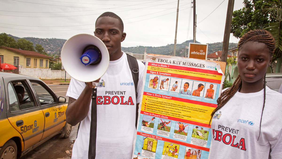 En man och en kvinna informerar om ebola i Sierra Leone.