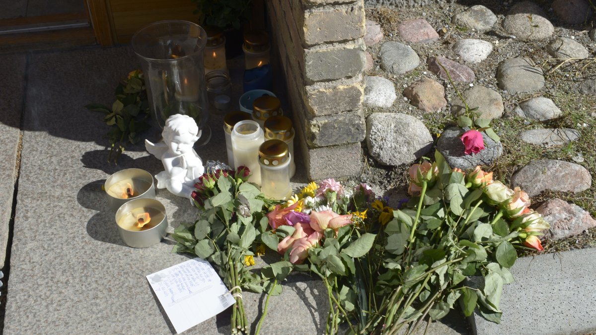 Blommor och ljus utanför den mördade 13-åringens port.