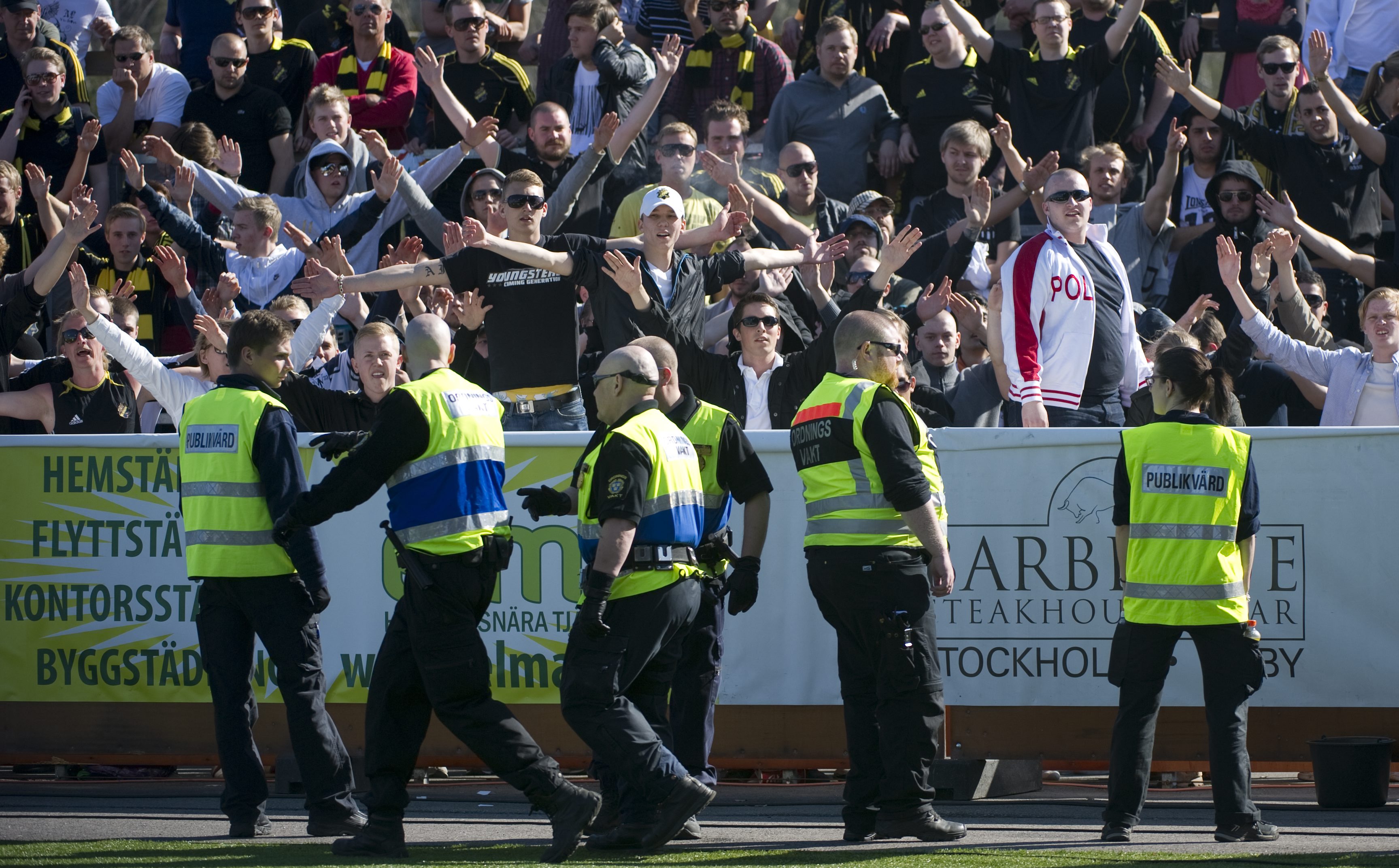 Säkerhetsvakter framför AIK-supportrarna.