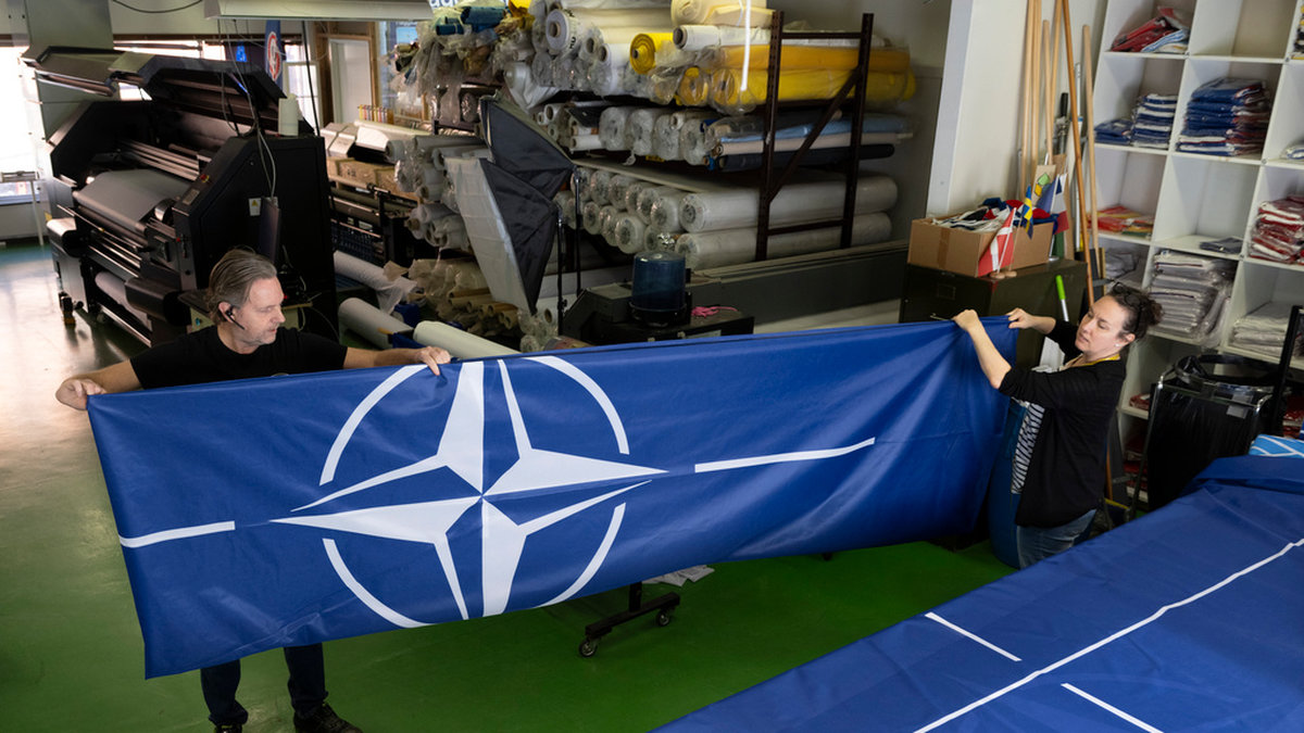 Stig Kvarnryd, vd på Flagghuset, och Tove Lycke, sömmerska, viker ihop en färdig Natoflagga.
