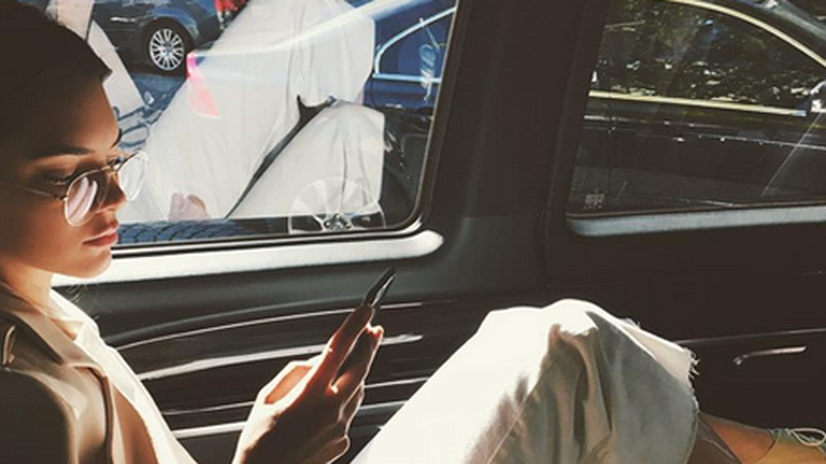 Kendall Jenner kollar mobilen. 