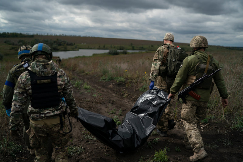 En död ukrainsk soldat bärs bort av sina kollegor i Charkiv-regionen nära den ryska gränsen. Arkivbild.