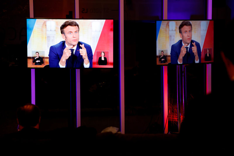 Tv-skärmar med Frankrikes president Emmanuel Macron under onsdagskvällens avslutande valdebatt.