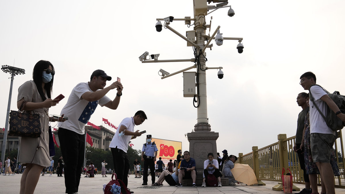 Besökare tar bilder på Himmelska fridens torg, under en mängd övervakningskameror. Arkivbild.