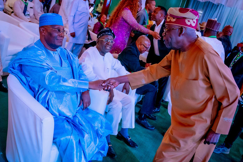Atiku Abubakar, sittande i blått, hälsar på sin rival Bola Tinubu. Bilden togs vid ett evenemang häromdagen då de skrev under ett 'fredsdokument' för att säkerställa att valet genomförs utan våld.
