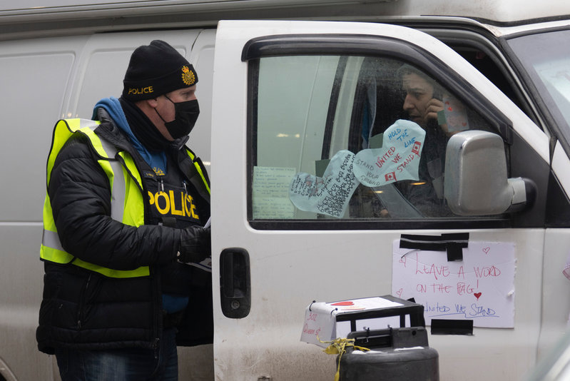 En protestant i samtal med en polis i den kanadensiska huvudstaden Ottawa på onsdagen.