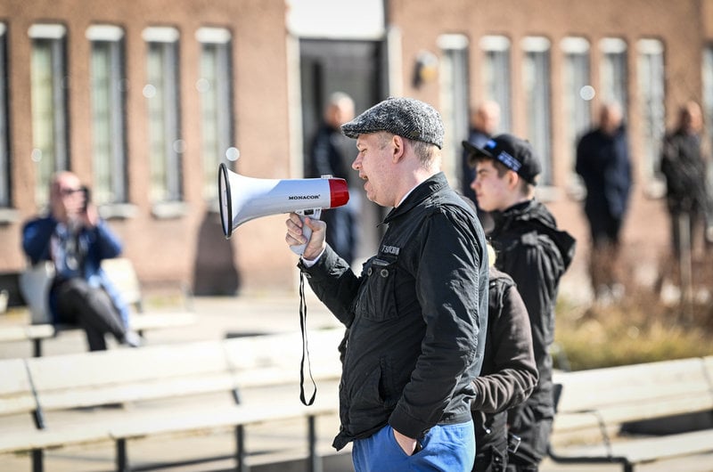 Rasmus Paludan, partiledare för det danska högerextrema partiet Stram kurs, med en megafon i handen, på plats i Stockholmsförorten Rinkeby på långfredagen.
