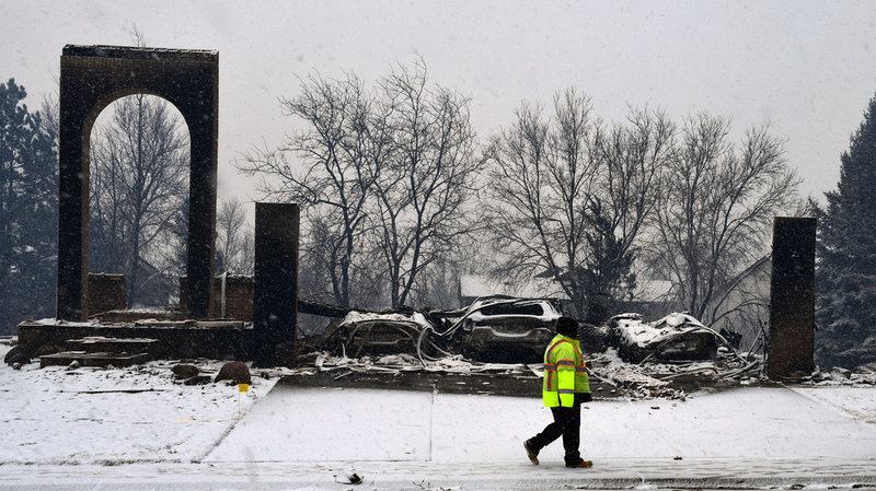 Snön faller över ett utbrunnet hem i Louisville.