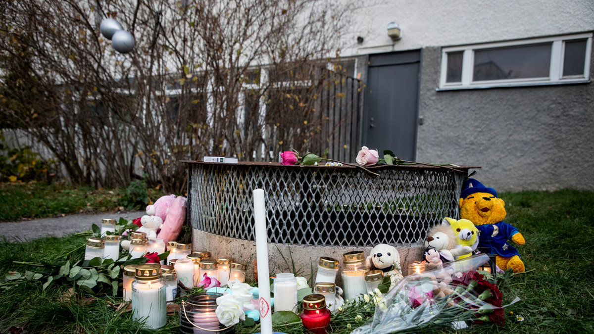 Gosedjur, blommor och ljus vid den plats där de två barnen hittades med livshotande i Hässelby i november förra året. Ett av barnen avled senare av sina skador. Arkivbild.