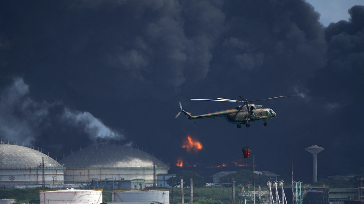 En helikopter har satts in för att vattenbomba branden i ett oljelager i Matanzas på Kuba.