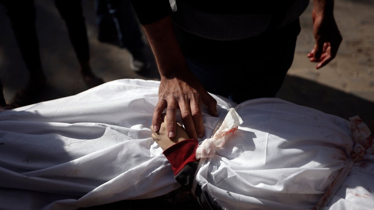 Ett barn som dödats i en israelisk attack insvept i ett lakan vid Nassersjukhuset i Khan Yunis. Bild från i januari.