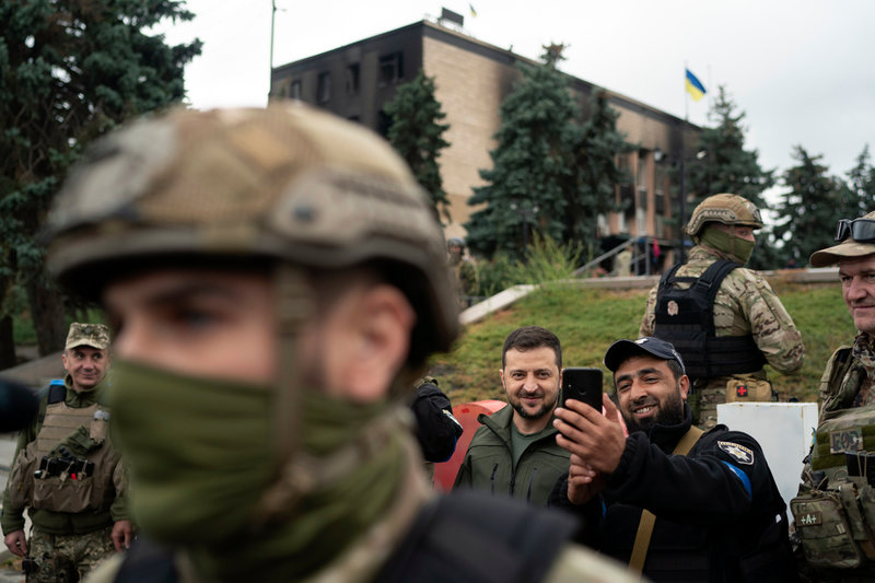 President Zelenskyj låter sig fotograferas med en polis i Izium på onsdagen.