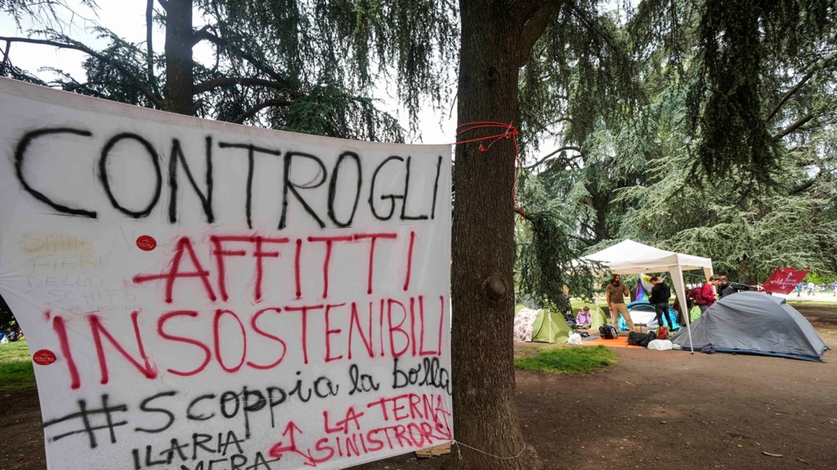 'Mot ohållbara hyror' står det på en banderoll som satts upp vid Politecnico di Milano, Italiens största universitet för teknik, arkitektur och design.