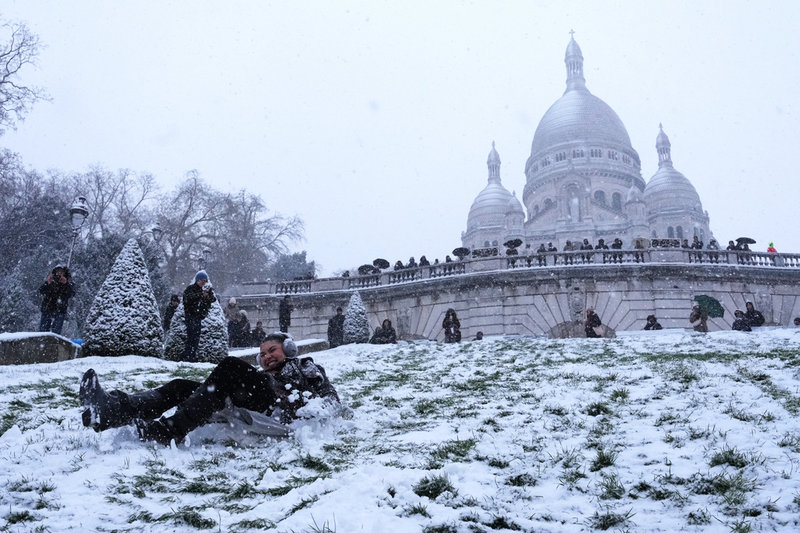 En kvinna glider nerför kullen vid Sacré-Coeur i Parisstadsdelen Montmartre.