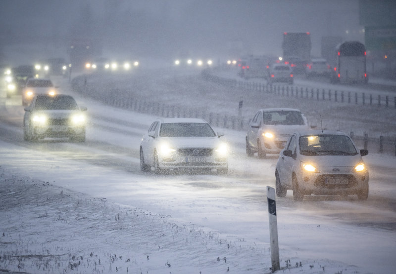Trafiken kröp fram på E6 medan snön yrde. Foto: Johan Nilsson/TT