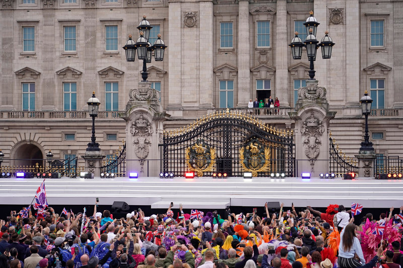 Drottning Elizabeth, omgiven av sin närmaste familj, vinkar åt den jublande folkmassan från Buckingham Palace balkong.