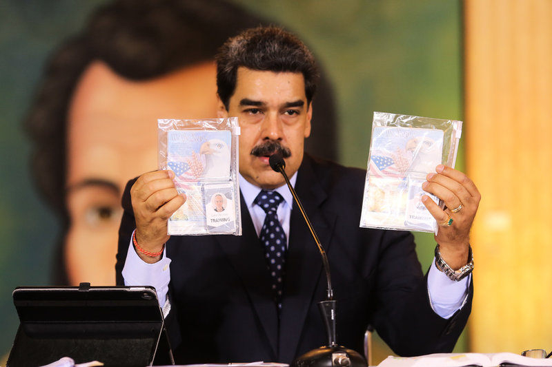Nicolás Maduro visar upp identitetshandlingar tillhörande två av de nu släppta exmilitärerna från USA. Männen misstänktes ha planerat en invasion.