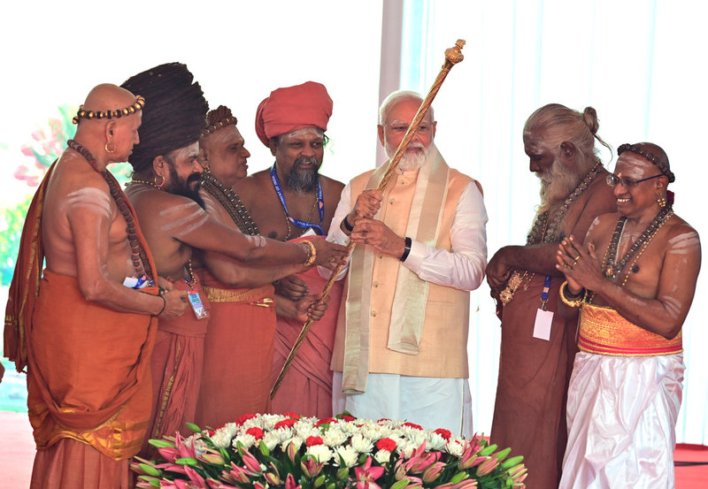En gyllene spira ska, enligt Modi och BJP, symbolisera maktöverföringen i Indien. I ceremonin bar Modi fram och installerade den vid talarstolen, flankerad av hinduiska präster.