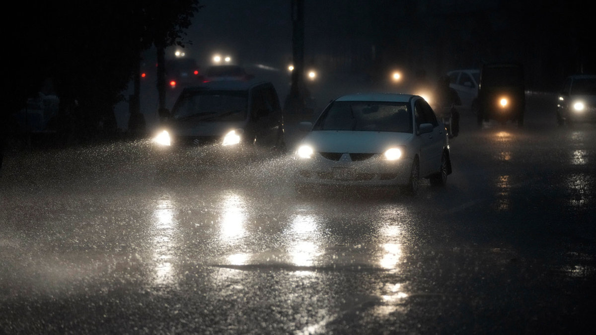 Bilar på en regnpiskad väg i Lahore i Pakistan.