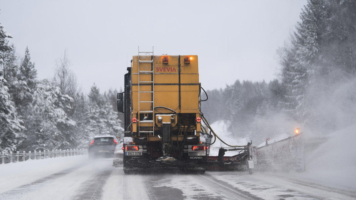 En plog- och saltbil håller vägen ren när snön faller över E18 nära Stockholm. Arkivbild.