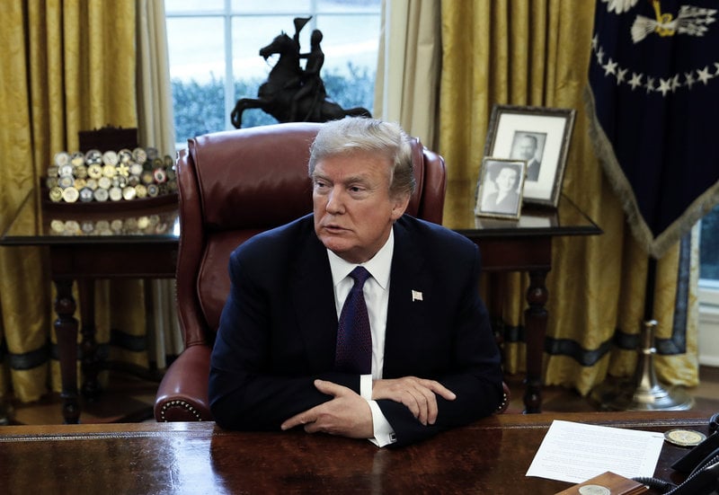 Donald Trump vid presidentens skrivbord i Ovala rummet, med foton på föräldrarna Mary Anne och Fred bakom sig. Bilden är tagen under hans första mandatperiod, men fotona står där nu igen.