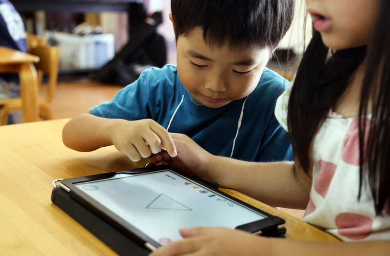 Japanska förskoleelever löser uppgifter på en läsplatta. De senaste åren har digitala verktyg införts på bred front i japanska skolor. Arkivbild.