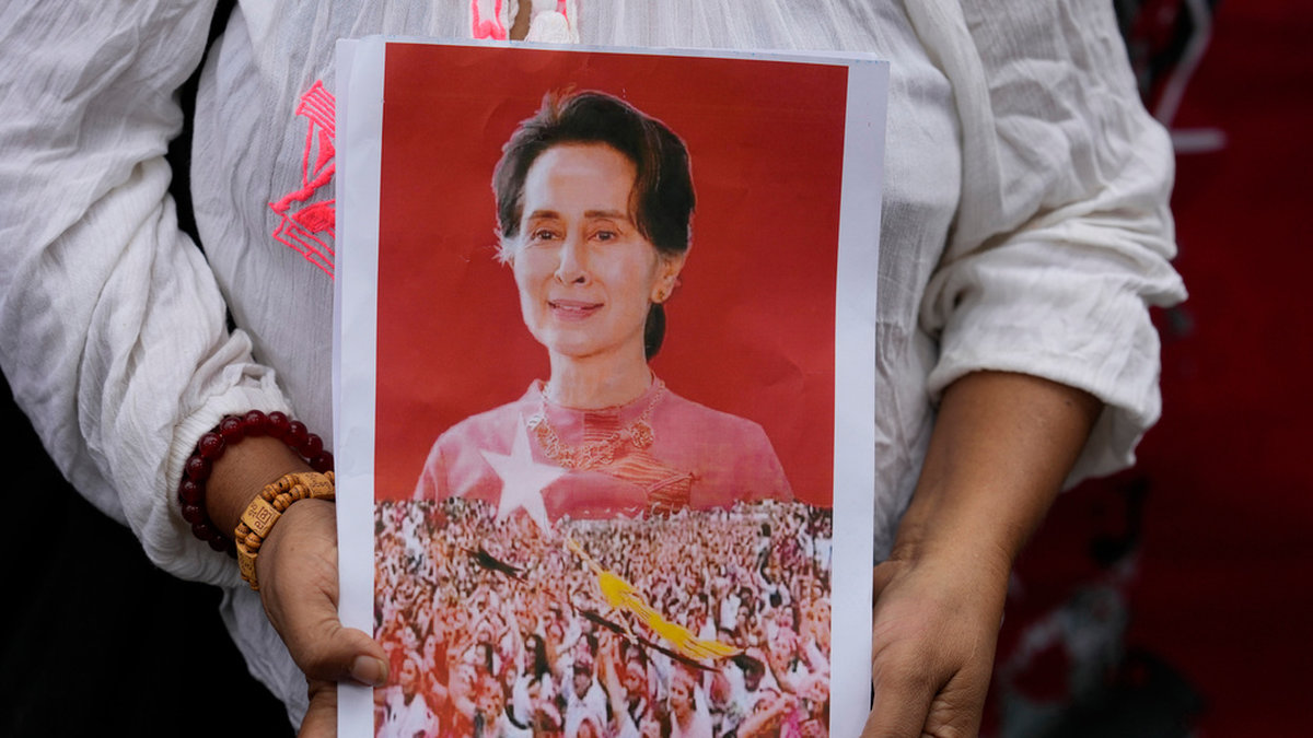 Myanmarier bosatta i Thailand håller ett porträtt på tidigare ledaren Aung San Suu Kyi. Arkivbild.