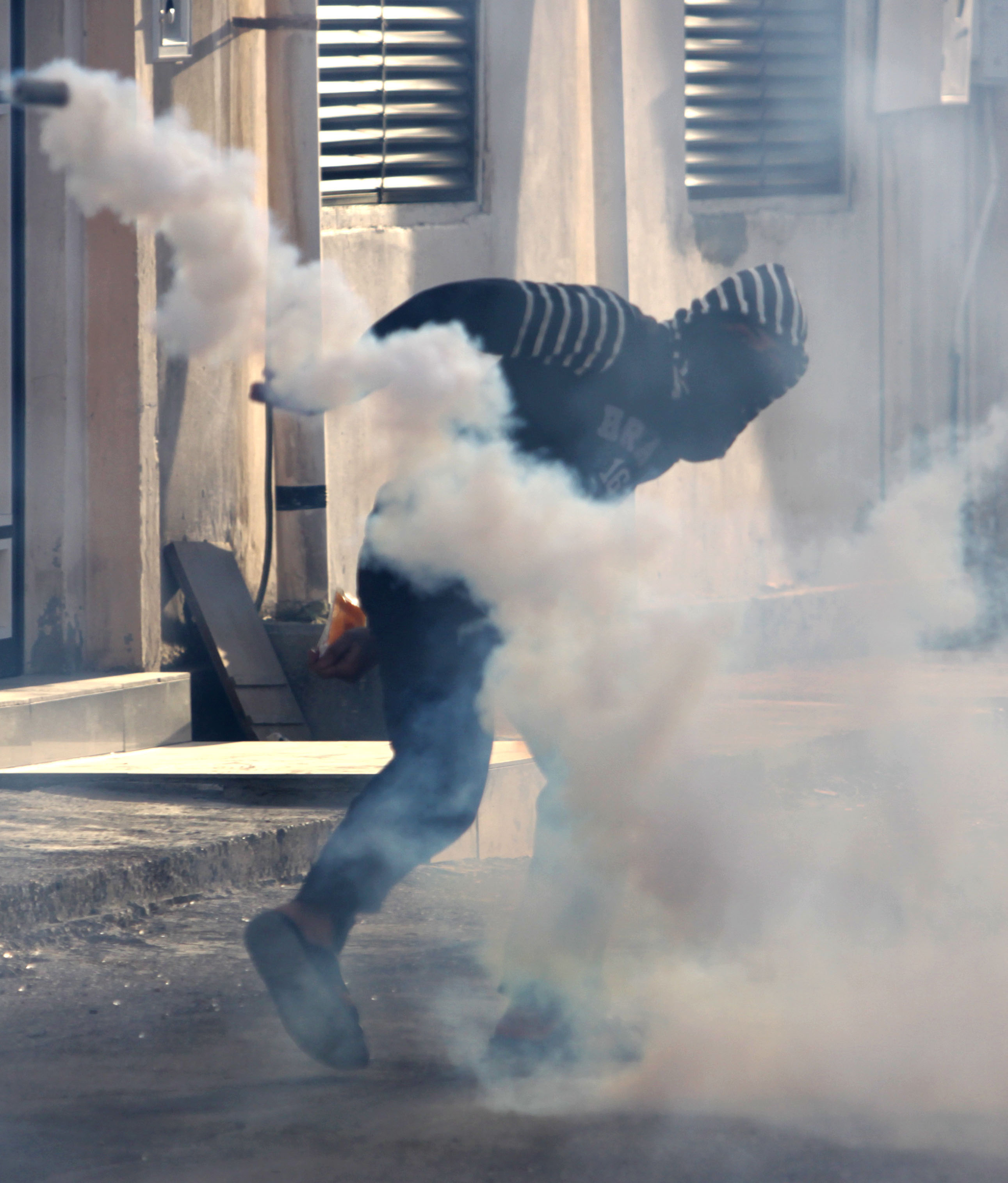 En man blir attackerad av kravallpolisens tårgas. Bahrain har fått internationell kritik för att man använt tårgas "på fel sätt".