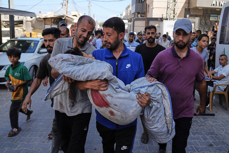 13-årige Seraje Ebrahim, som också dödades i söndagens israeliska attack mot en vattenkö, bärs bort av familjemedlemmar.